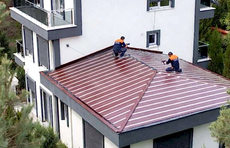 Antalya Belek Çatı Onarım ve Tadilat 2025 1 Antalya Belek Çatı Onarım ve Tadilat 2025, Antalya Belek’te modern mimarili lüks villaya bordo renk sandviç panel çatı montajı.